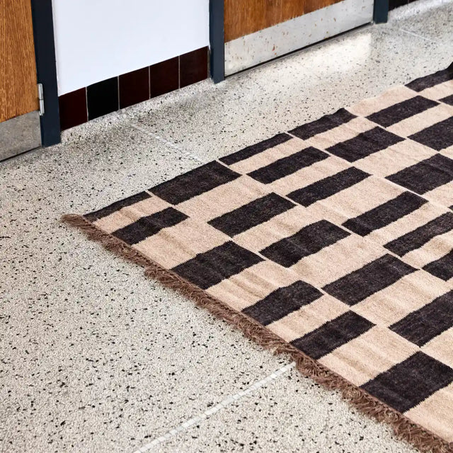 Teppich Graph in Schwarz und Natur mit asymmetrischem Muster und Fransen von House Doctor – Wohnbeispiel (230 × 160 cm)