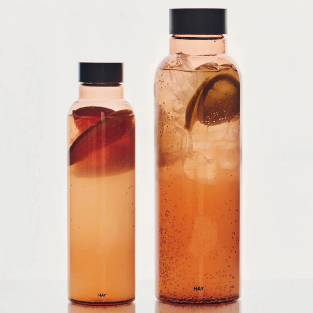 HAY Miz Trinkflasche No. 2 in der Farbe Mauve mit Orangenschalen gefüllt