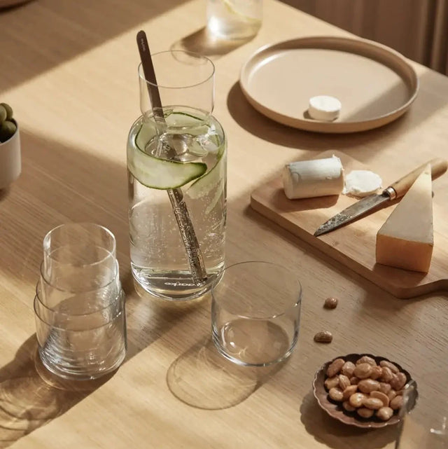 Aarke Nesting Carafe mit Gurkenwasser und Barlöffel auf gedecktem Holztisch